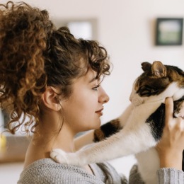 a woman holding her pet in a bright area