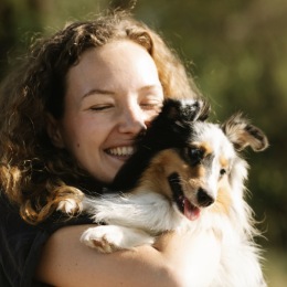a woman holding her pet outdoors